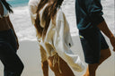 People walking on the beach in hoodies and matching sets.
